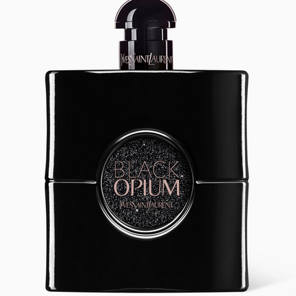 A black rectangular perfume bottle with a glossy finish, featuring a circular black label with gold glittery text that reads 'BLACK OPIMUM MINNIVALENTE'. The bottle is centered against a clean white background.